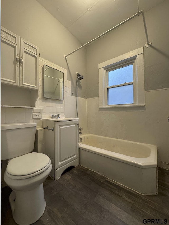 full bath with tub / shower combination, toilet, wood finished floors, and vanity