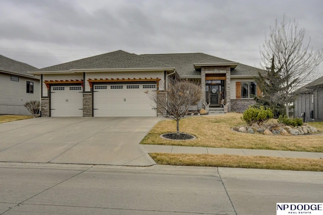 prairie-style house featuring concrete driveway, an attached garage, stone siding, and roof with shingles