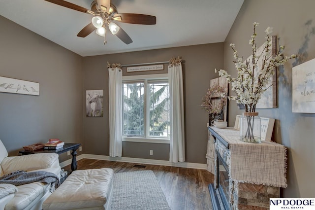 sitting room with ceiling fan, baseboards, and wood finished floors