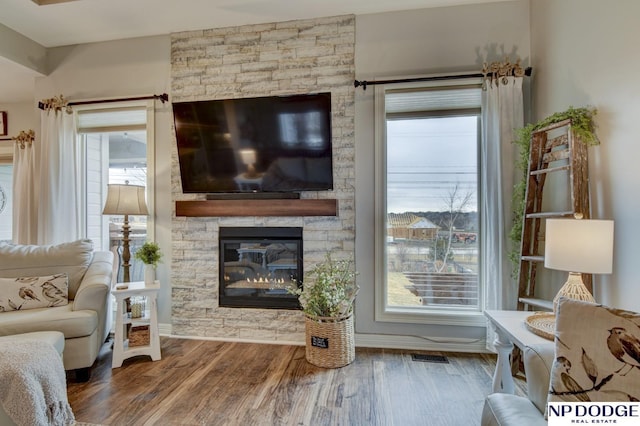 living area featuring plenty of natural light, wood finished floors, and visible vents