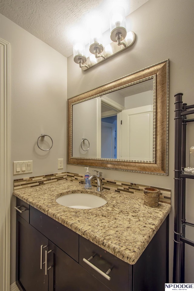 bathroom with a textured ceiling and vanity