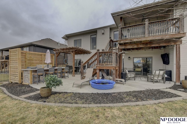 back of house with outdoor dry bar, stairway, an outdoor fire pit, a pergola, and a patio