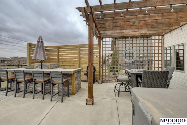 view of patio / terrace with outdoor dining area, a pergola, and outdoor dry bar