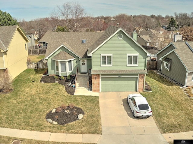 view of front of house with a front yard, fence, driveway, a garage, and brick siding