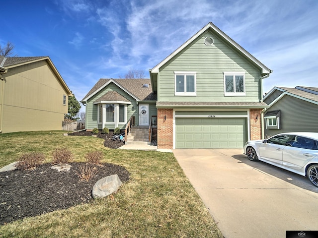 tri-level home featuring a front yard, a garage, brick siding, and driveway