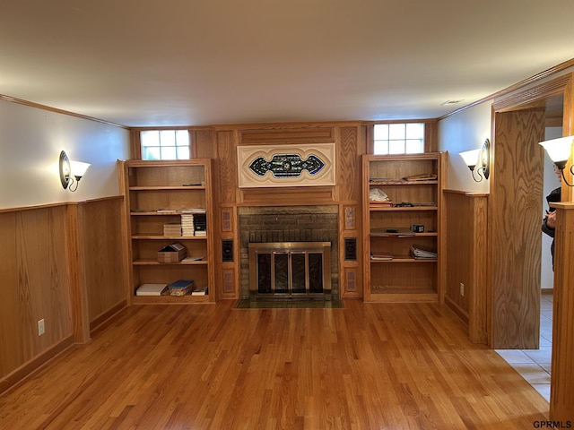 living room with wood finished floors, plenty of natural light, wainscoting, and a fireplace