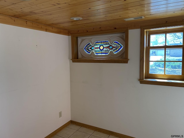 unfurnished room featuring light tile patterned floors, visible vents, baseboards, and wooden ceiling