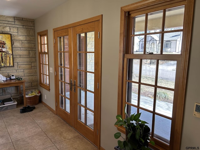 entryway with light tile patterned floors, french doors, and baseboards