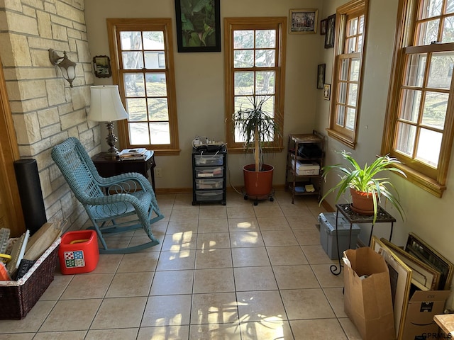 sitting room featuring light tile patterned flooring, a healthy amount of sunlight, and baseboards