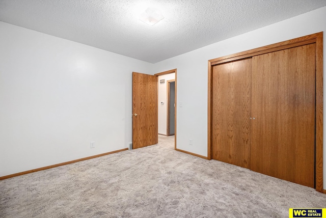 unfurnished bedroom with a closet, baseboards, a textured ceiling, and carpet flooring