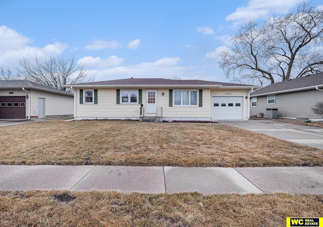 ranch-style home with a garage, central air condition unit, a front yard, and driveway