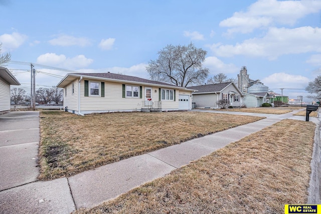 ranch-style house featuring a front yard and a garage