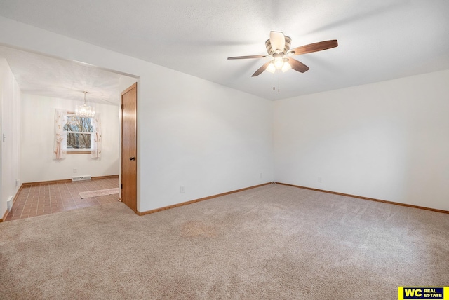 carpeted empty room with visible vents, baseboards, and ceiling fan with notable chandelier