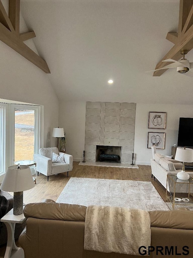 living room with a fireplace, lofted ceiling, wood finished floors, and baseboards