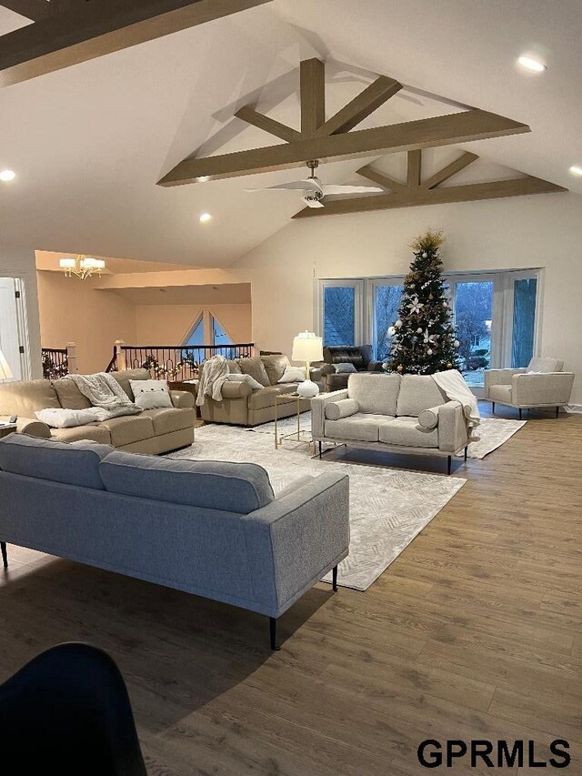 living area featuring wood finished floors, high vaulted ceiling, recessed lighting, beamed ceiling, and ceiling fan with notable chandelier