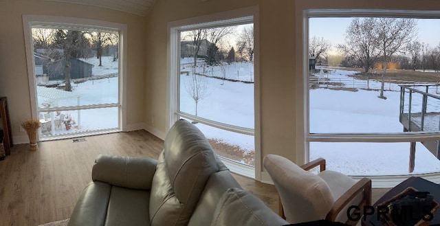 interior space with visible vents, lofted ceiling, baseboards, and wood finished floors