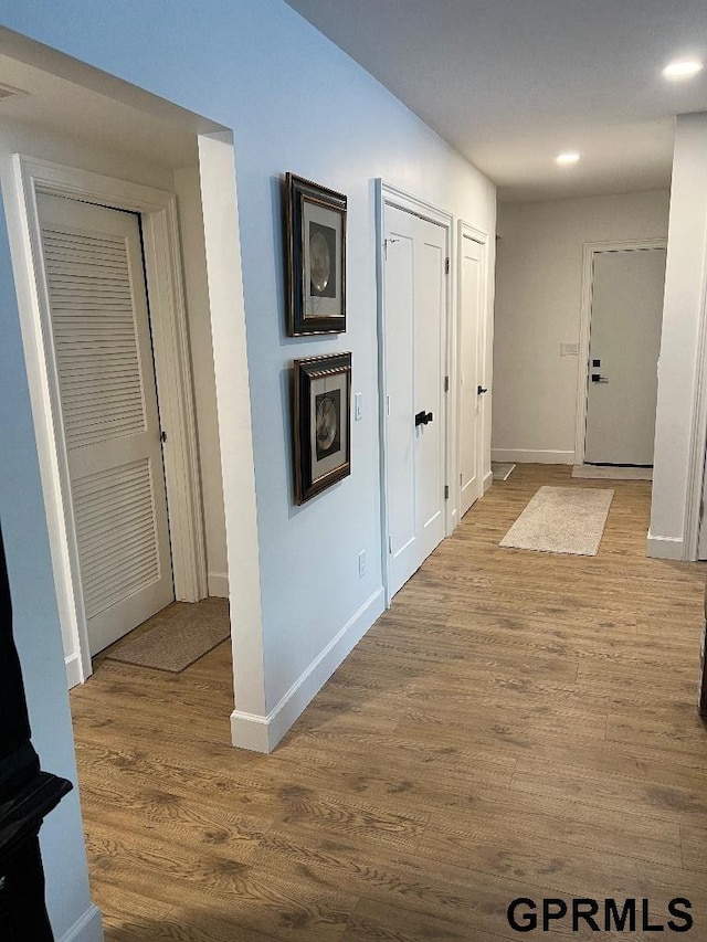 corridor featuring recessed lighting, wood finished floors, and baseboards