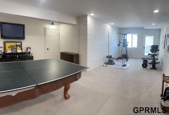 rec room featuring carpet flooring, recessed lighting, brick wall, and baseboards