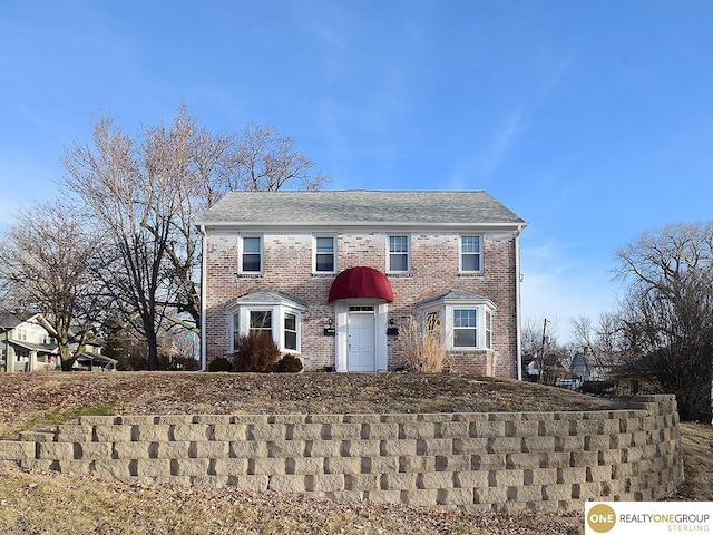 colonial house featuring brick siding