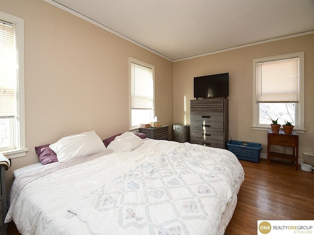 bedroom with crown molding and wood finished floors