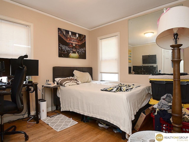 bedroom with wood finished floors and ornamental molding