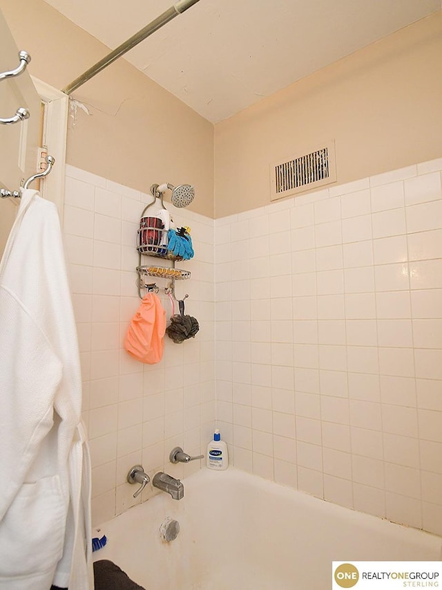 bathroom with visible vents and shower / bath combo with shower curtain