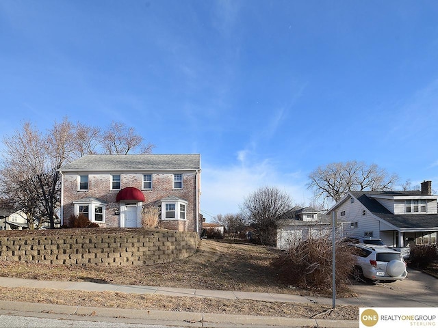 view of front facade featuring brick siding and driveway