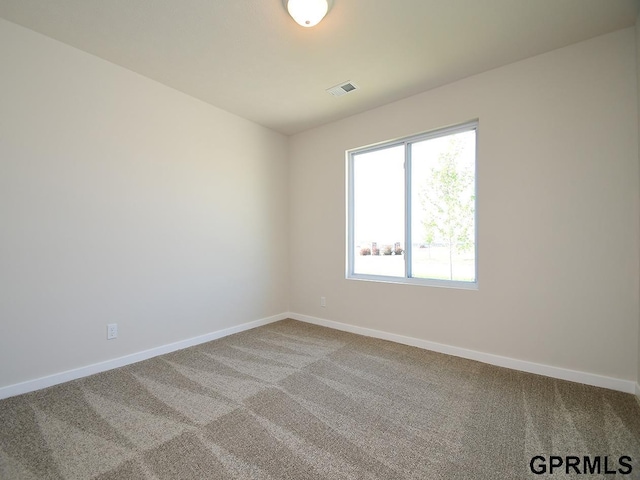 carpeted empty room featuring visible vents and baseboards