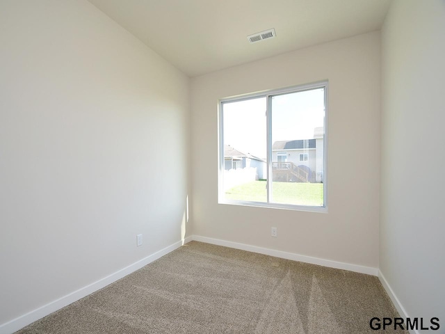 spare room featuring visible vents, baseboards, and carpet