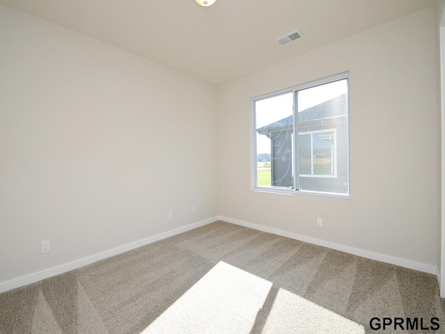 carpeted empty room featuring visible vents and baseboards