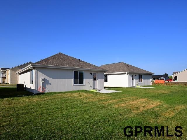 rear view of property with a lawn