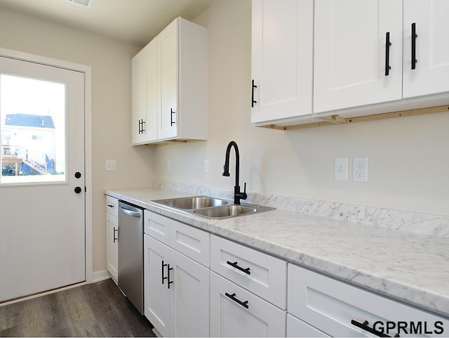 kitchen with a sink, light stone countertops, stainless steel dishwasher, white cabinetry, and dark wood-style flooring