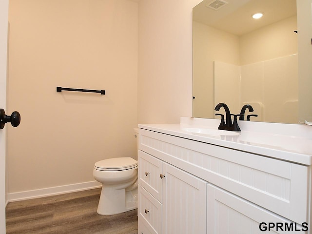 full bath featuring visible vents, toilet, wood finished floors, baseboards, and vanity