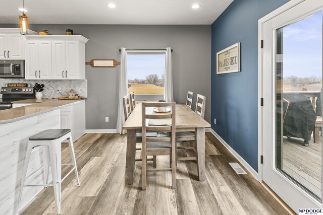 dining room with visible vents, recessed lighting, light wood-style floors, and baseboards