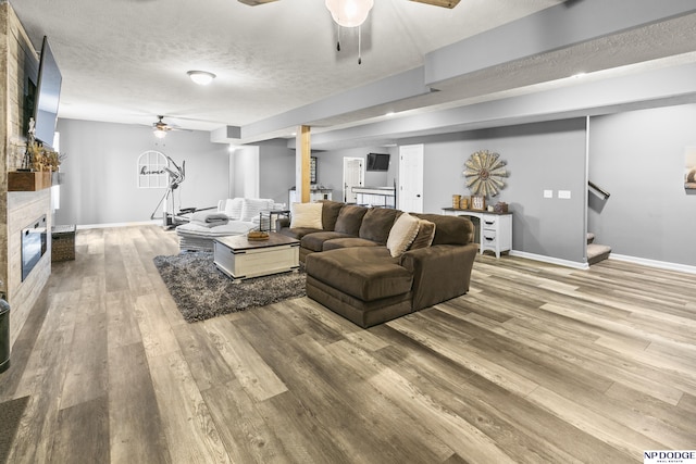 living room featuring stairway, a ceiling fan, and wood finished floors