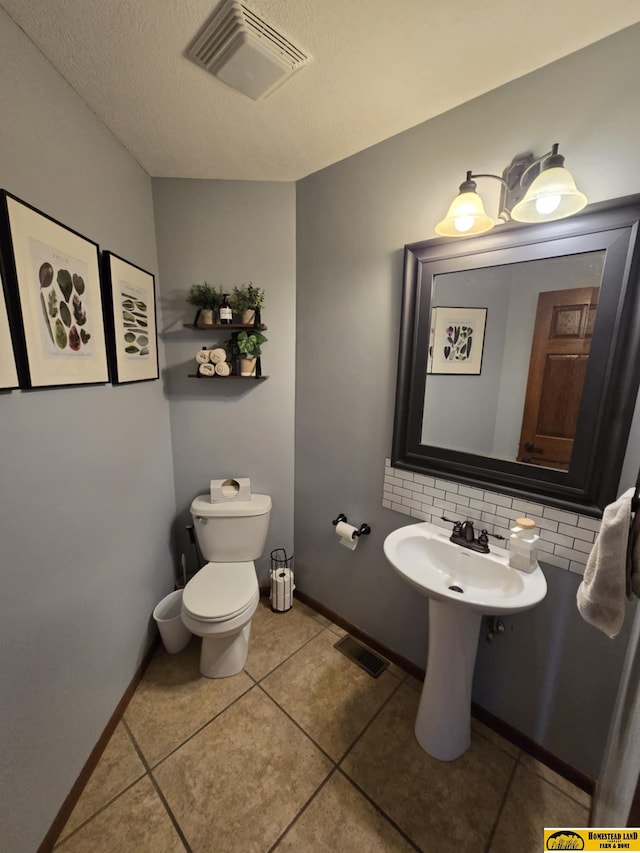 bathroom with tile patterned floors, visible vents, toilet, and tasteful backsplash