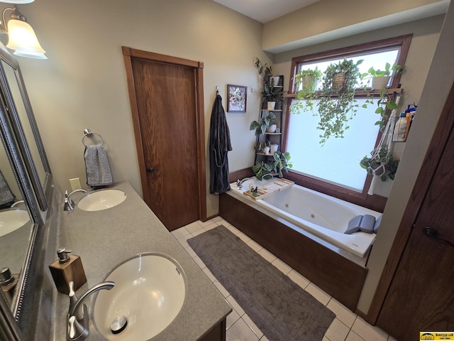 full bathroom with a sink, a jetted tub, double vanity, and tile patterned floors