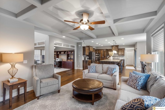 living area featuring baseboards, beam ceiling, coffered ceiling, and wood finished floors