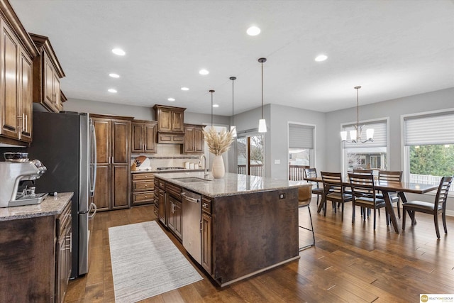 kitchen featuring recessed lighting, a sink, dark wood-type flooring, a center island with sink, and appliances with stainless steel finishes
