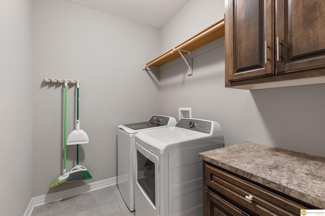 laundry room with separate washer and dryer, cabinet space, light tile patterned floors, and baseboards