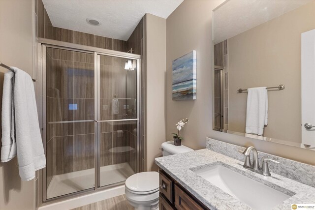 full bathroom featuring vanity, toilet, and a stall shower