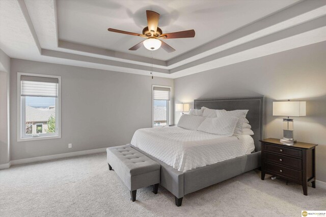 bedroom with ceiling fan, a raised ceiling, baseboards, and carpet floors