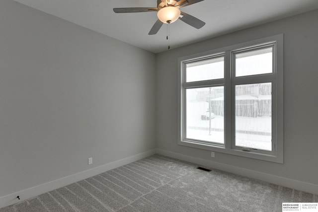 unfurnished room featuring a ceiling fan, carpet flooring, baseboards, and visible vents