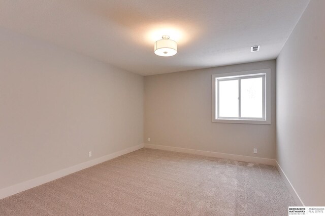 spare room with visible vents, baseboards, and light colored carpet