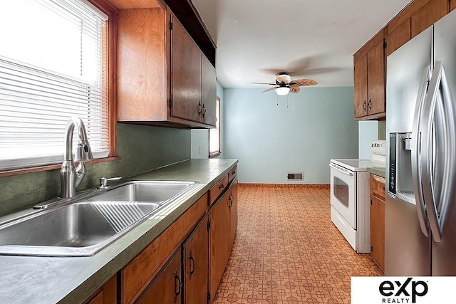 6027 S 36th St, Omaha, NE 68107 - kitchen with electric range, visible vents, a ceiling fan, a sink, and stainless steel fridge