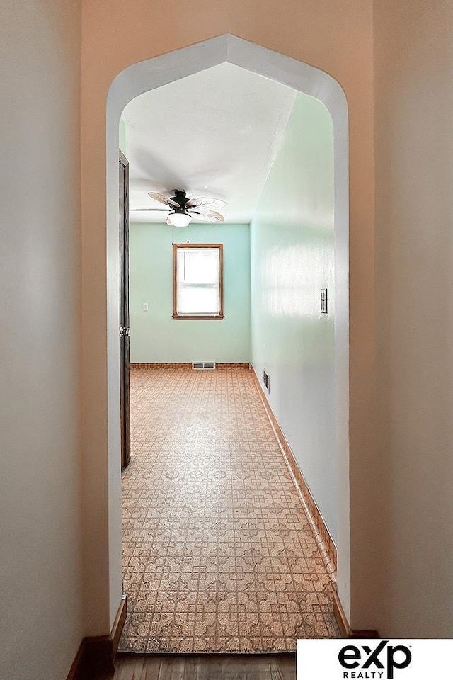 6027 S 36th St, Omaha, NE 68107 - empty room with arched walkways, visible vents, baseboards, and a ceiling fan