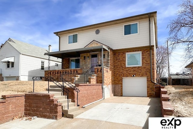 6027 S 36th St, Omaha, NE 68107 - view of front of property featuring a garage, brick siding, covered porch, and driveway
