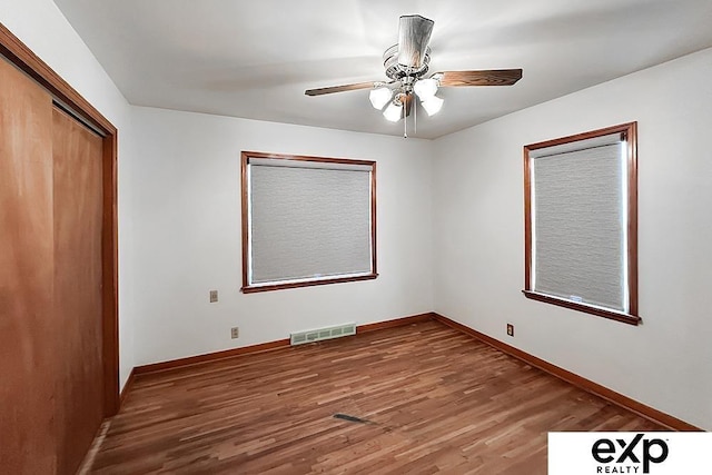 6027 S 36th St, Omaha, NE 68107 - unfurnished bedroom with wood finished floors, visible vents, baseboards, ceiling fan, and a closet