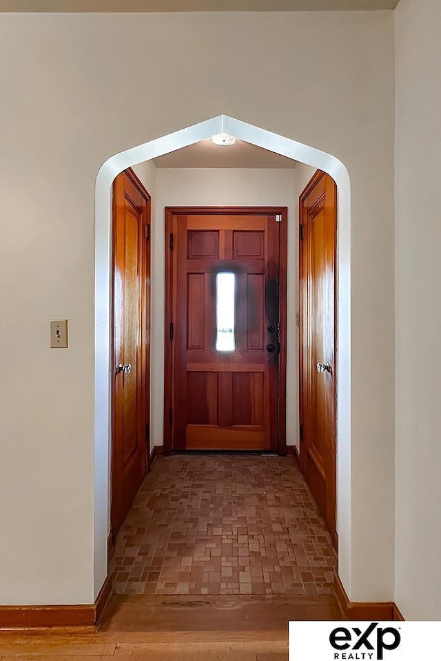 6027 S 36th St, Omaha, NE 68107 - entryway featuring brick floor, baseboards, and arched walkways