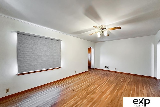 6027 S 36th St, Omaha, NE 68107 - spare room featuring light wood finished floors, visible vents, baseboards, arched walkways, and a ceiling fan